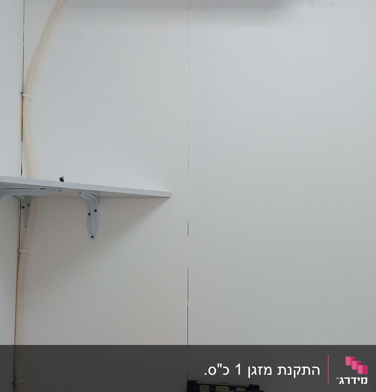 מזגן מותקן על קיר עם צינור חיבור לבן